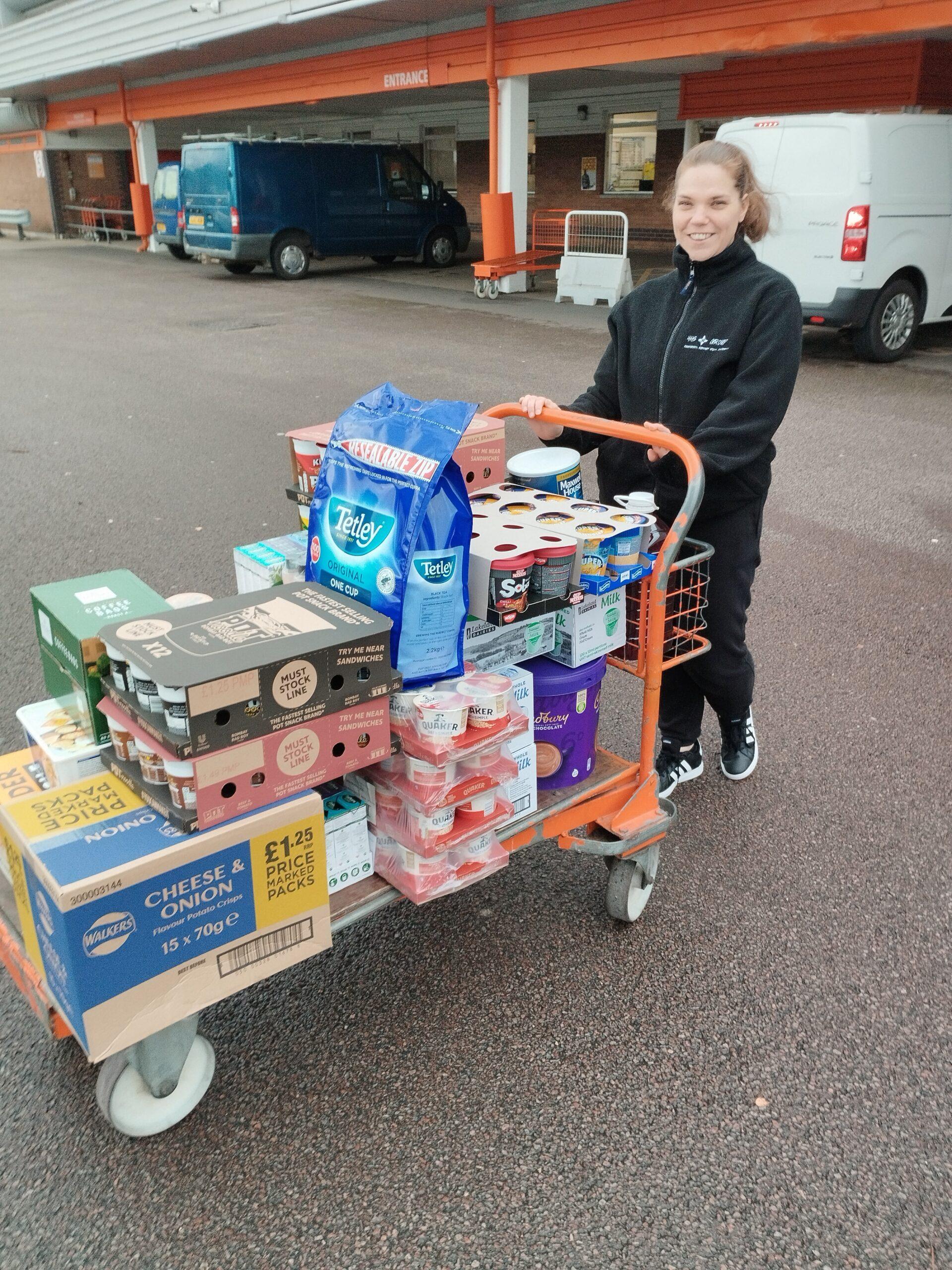 HHS Group staff delivering a Bookers trolley of supplies donated to a winter shelter