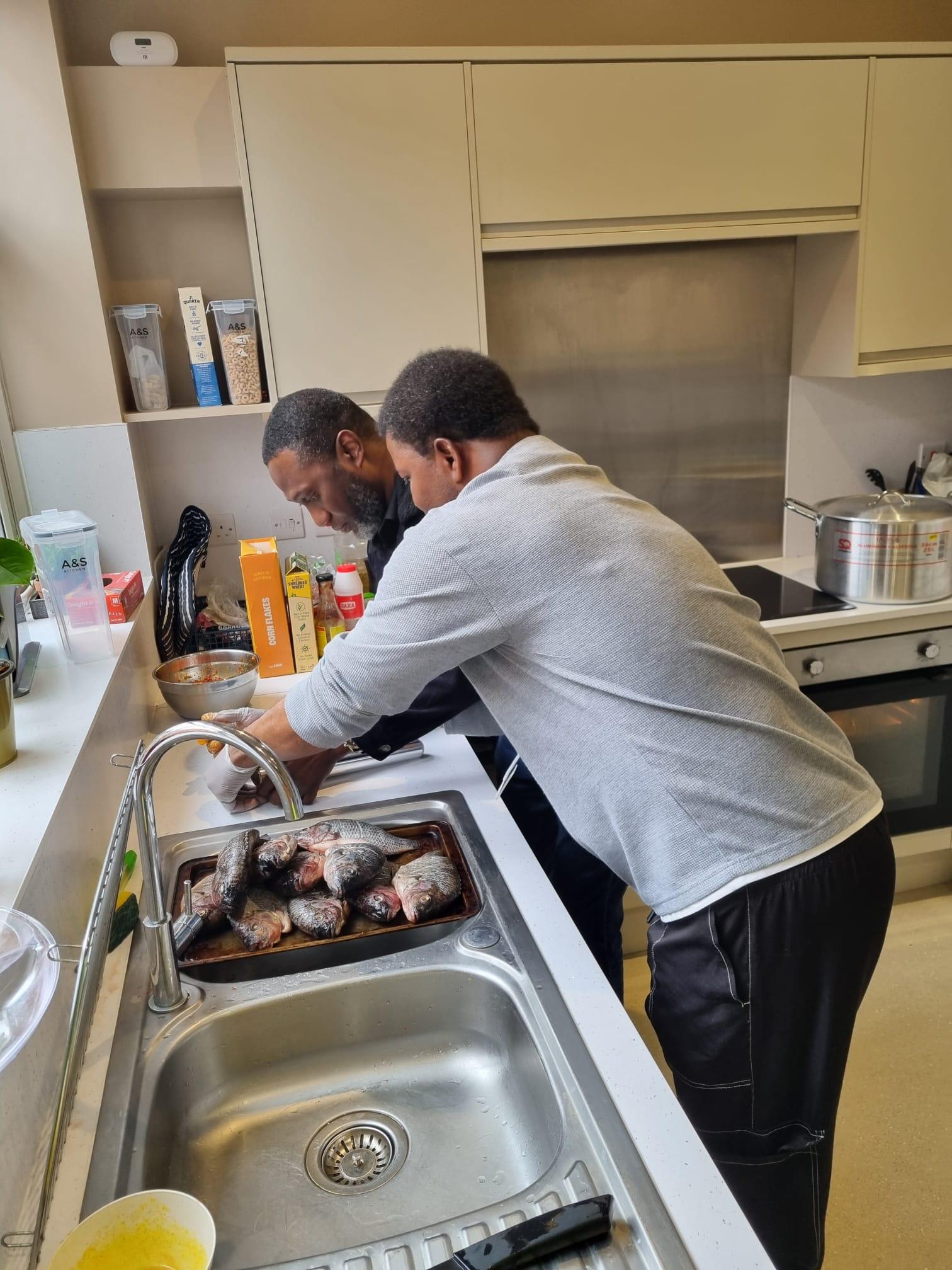 HHS Group staff preparing and cooking food for a community barbecue event