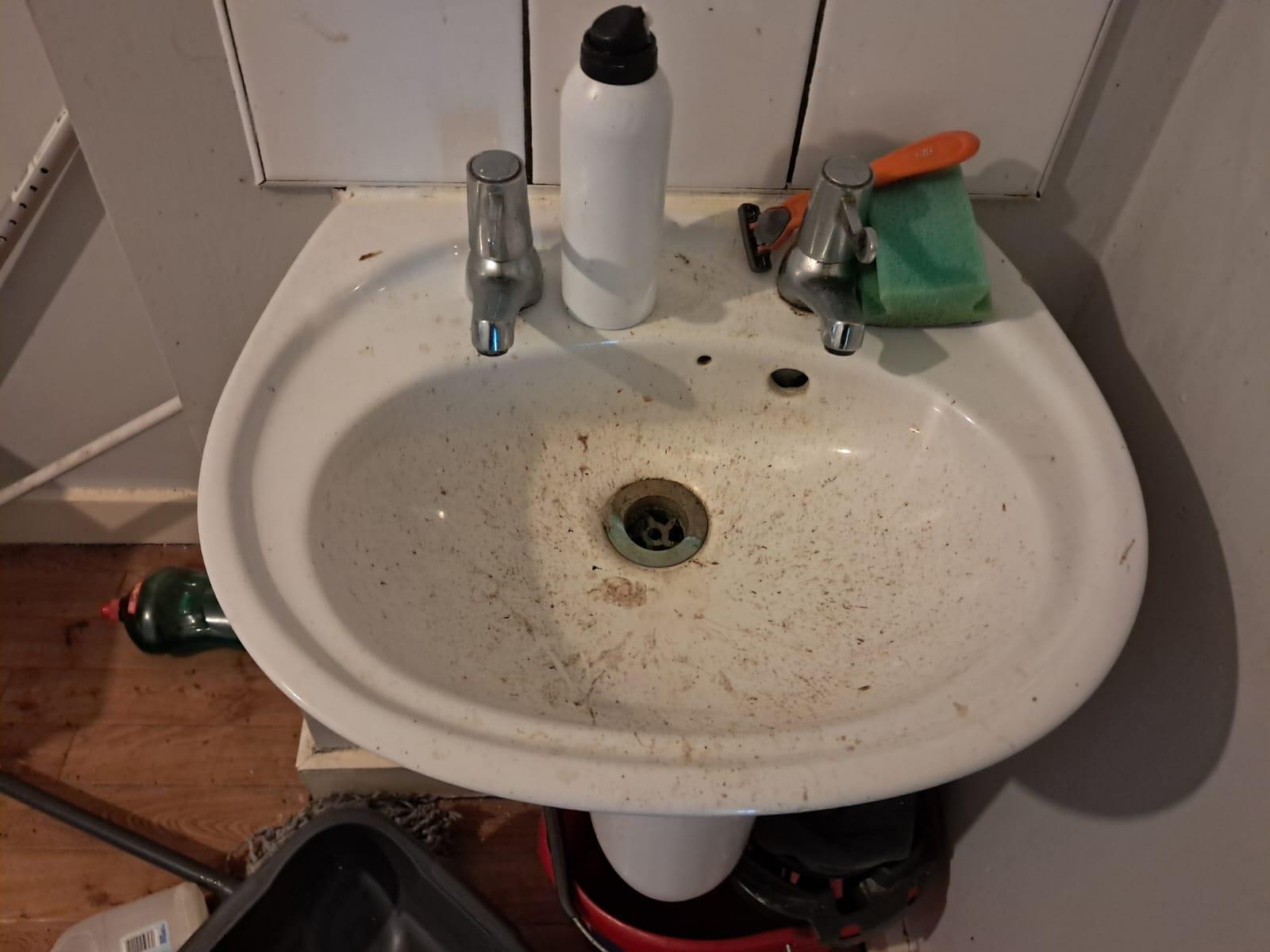 Grimy bathroom sink before a deep clean at a supported housing site