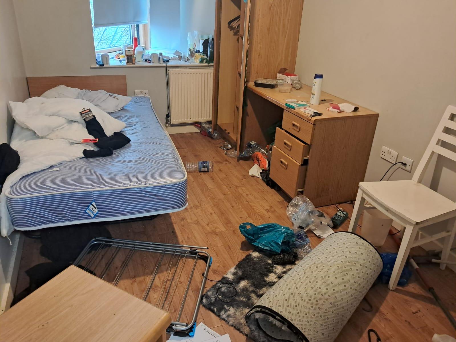 Cluttered bedroom with rubbish on the floor before a deep clean
